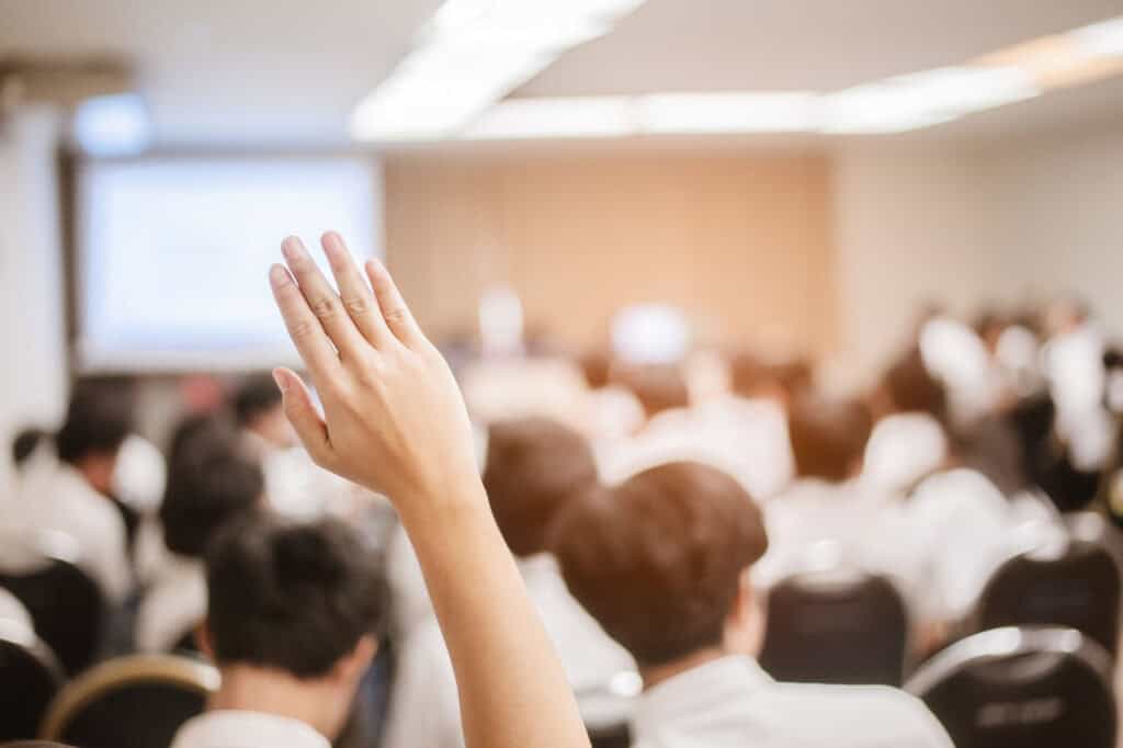 Sondez la salle avec une personne levant la main lors d'une présentation ou d'une réunion.