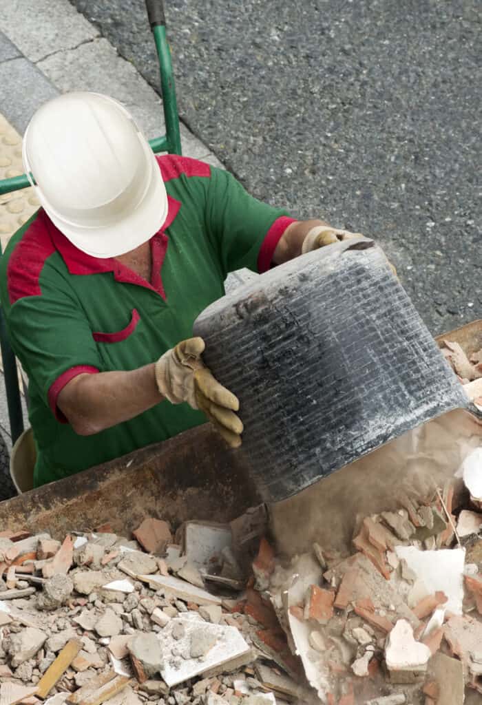 Porteur de déchets de chantier manipulant des matériaux de construction pour le tri.
