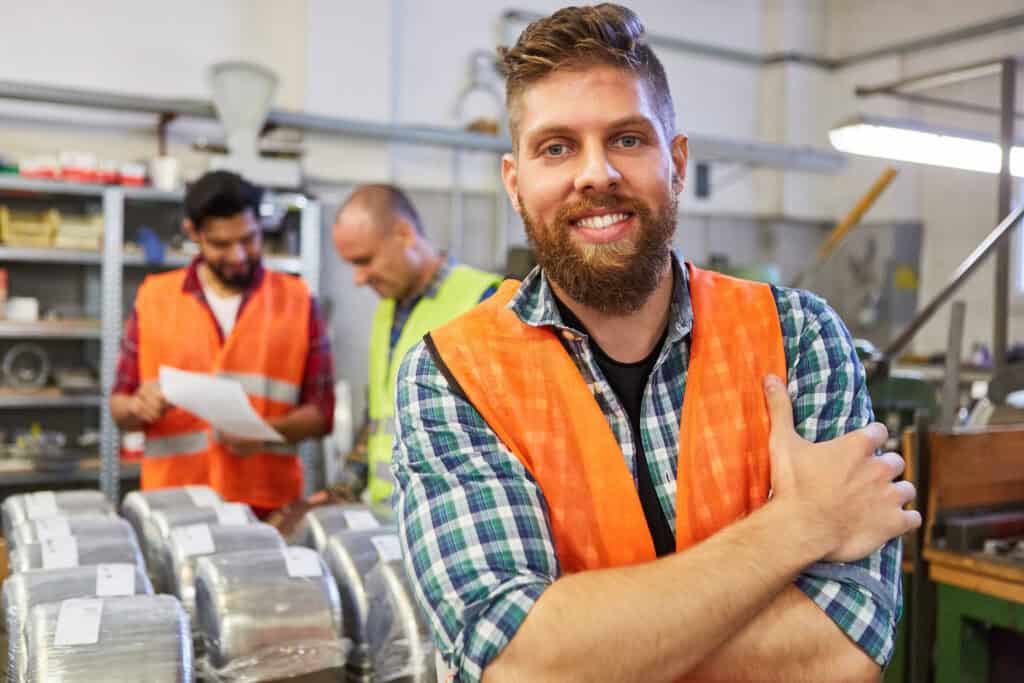 Distributeur pour matériaux de construction dans une usine, avec employés en sécurité.