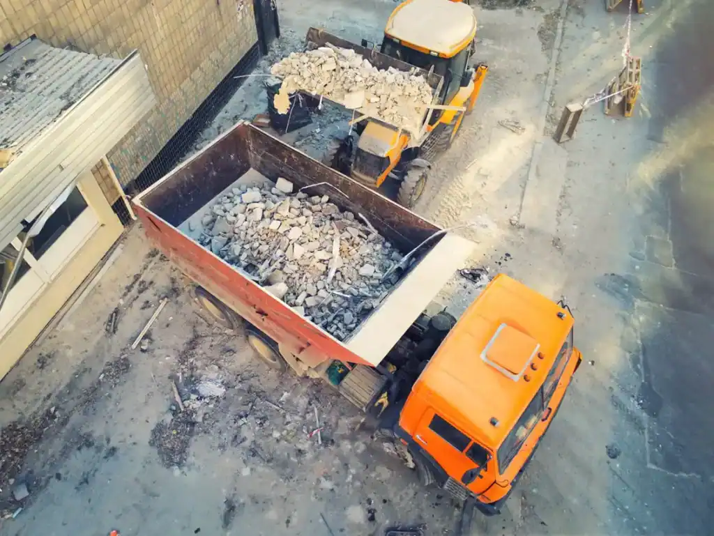 Camion de chantier en action pour recyclage de débris de construction.