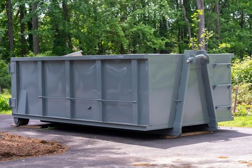 Conteneur à déchets gris dans un environnement naturel.